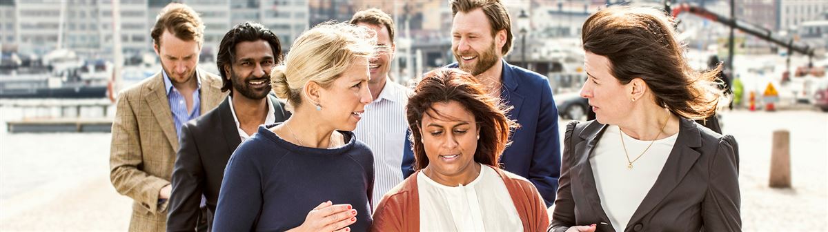 Kollegor promenenerar utomhus i vackert väder