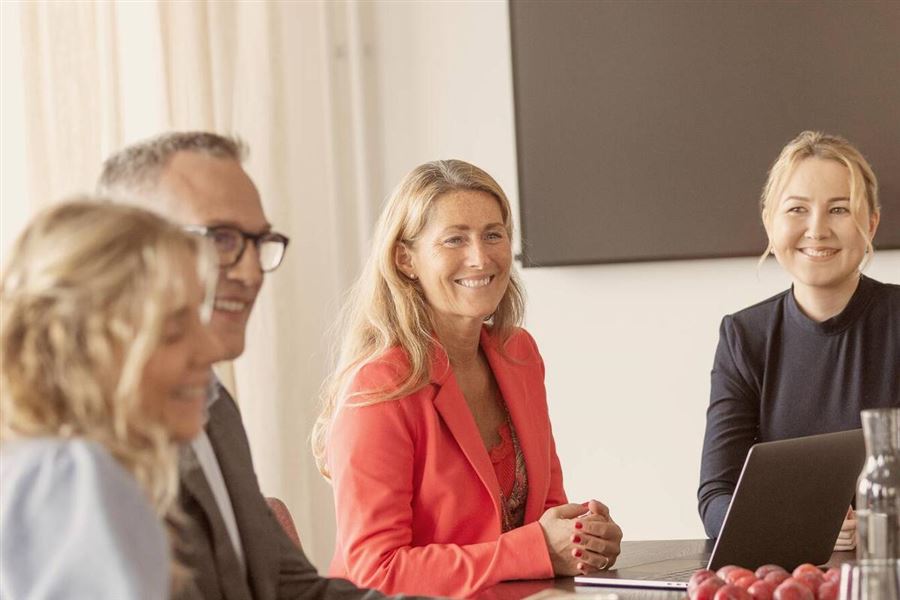 Four colleagues are having a meeting at a branch office. They look happy.