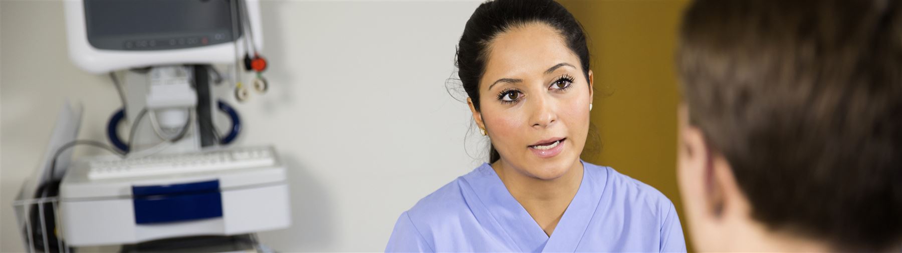 Kvinnlig läkare talar till patient.
